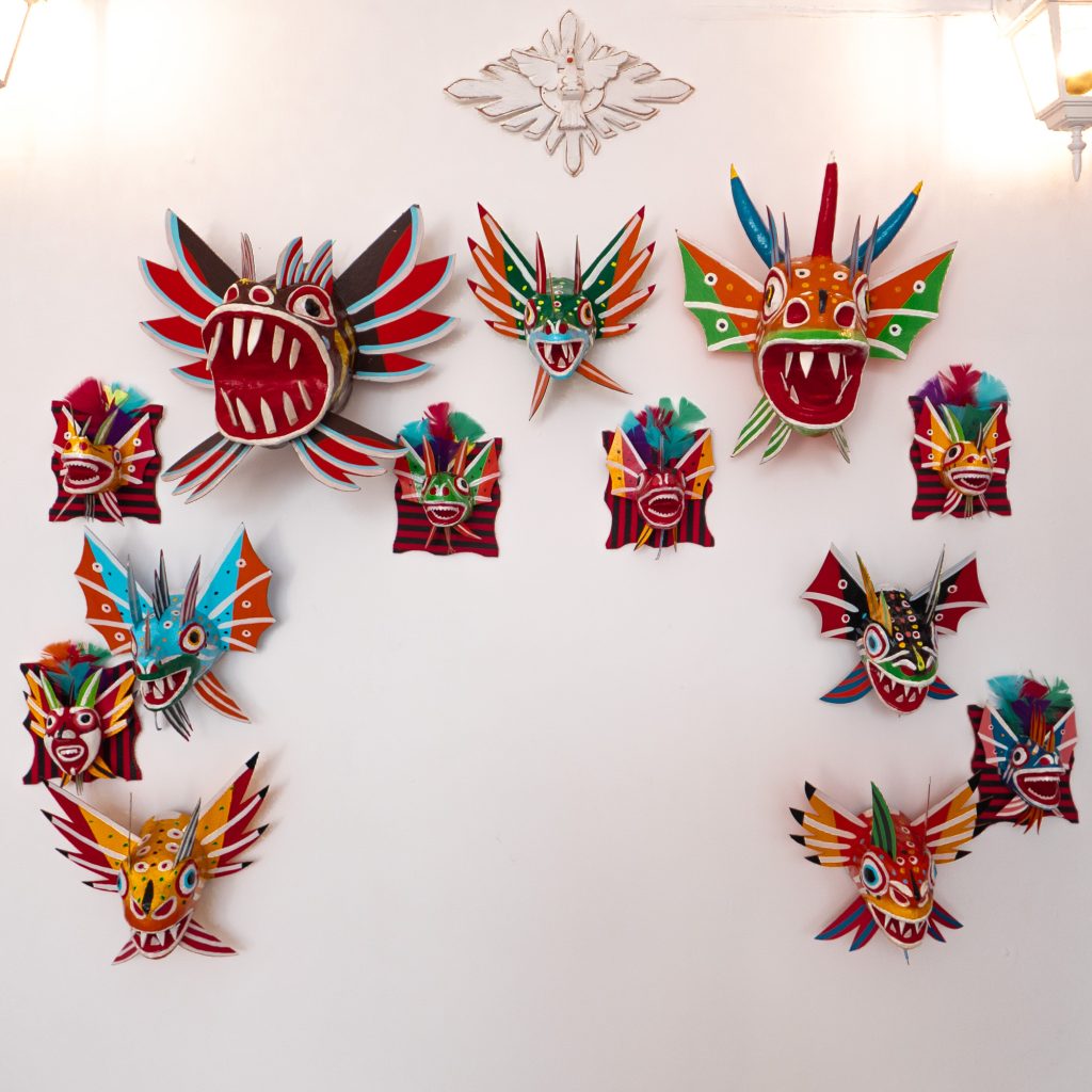 Wall display of traditional Panamanian diablo masks in vibrant colors at Joyas Selectas in Casco Viejo.