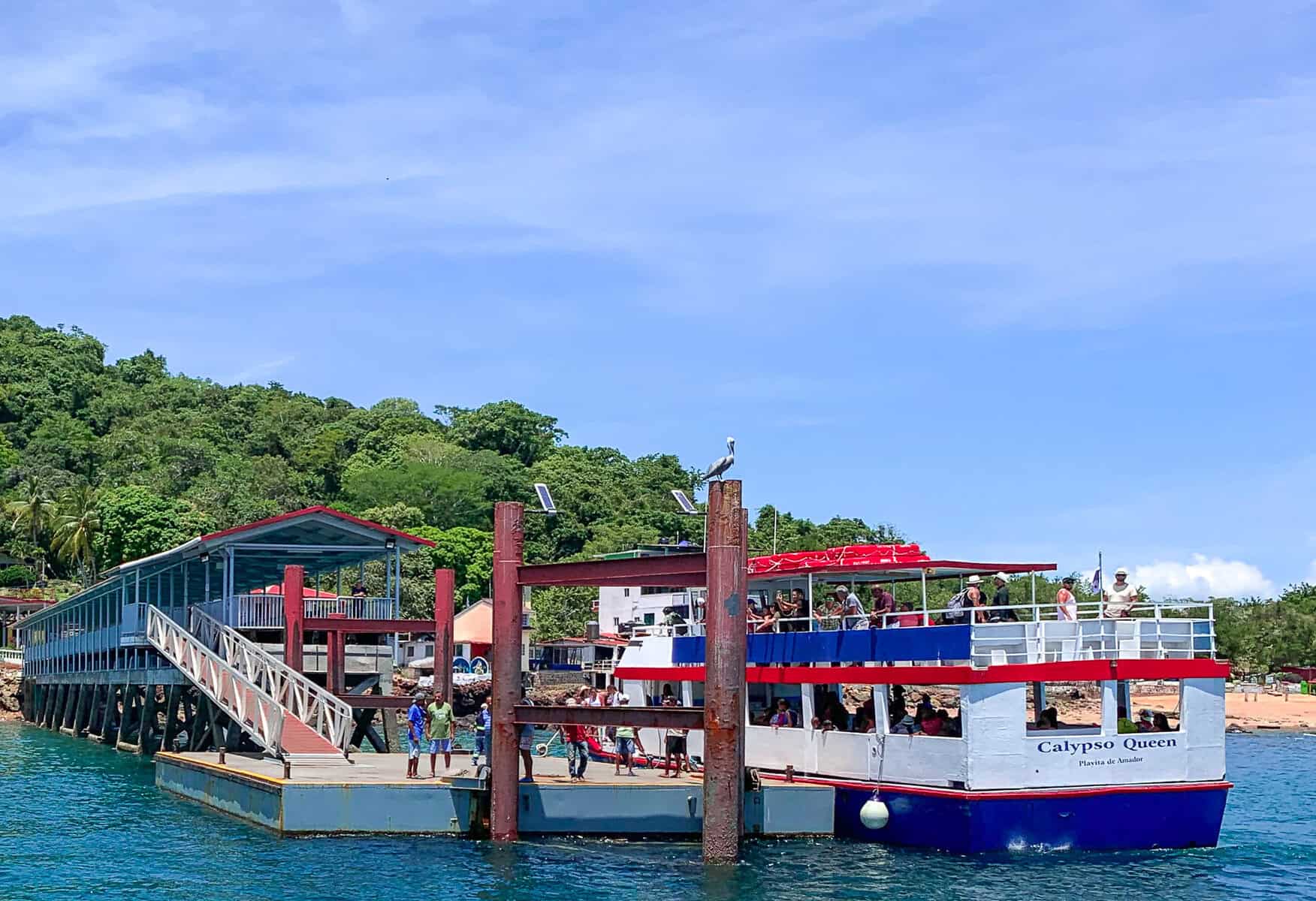 Passenger ferry docked at Taboga Island pier with visitors boarding from the waterfront