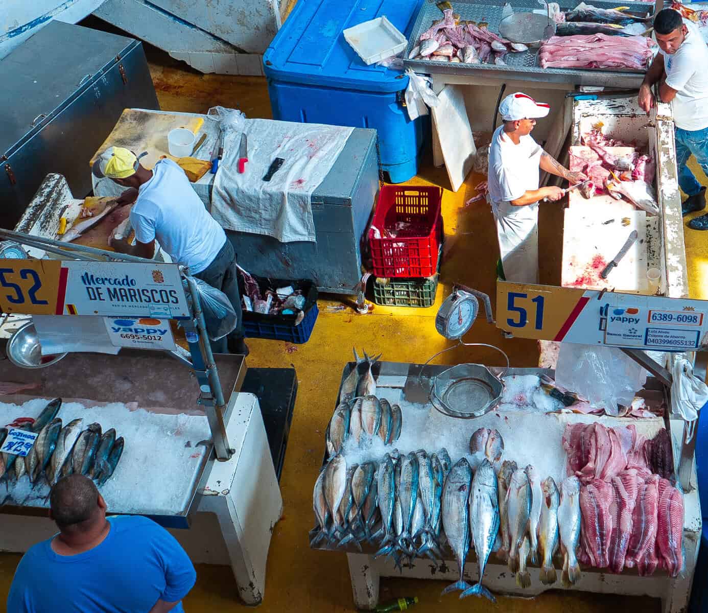 Seafood vendors prepare and cut fish at individual stalls inside the Casco Viejo Fish Market in Panama City.
