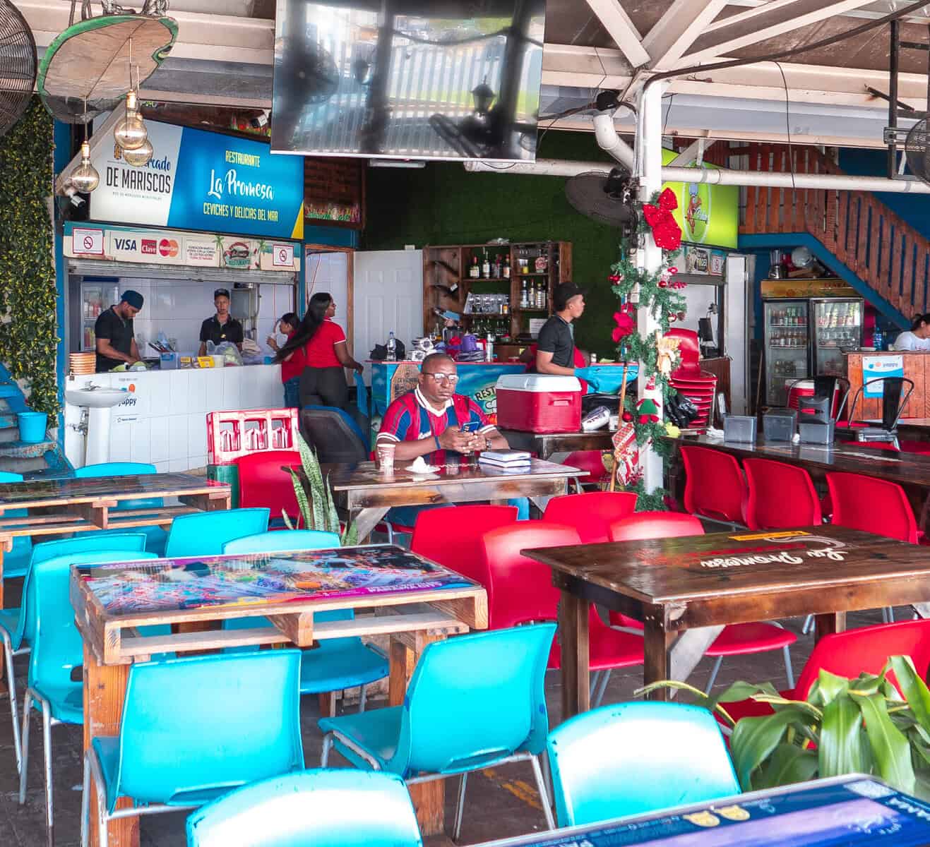 Outdoor dining tables outside the Casco Viejo Fish Market where locals sit and eat freshly prepared seafood in Panama City.