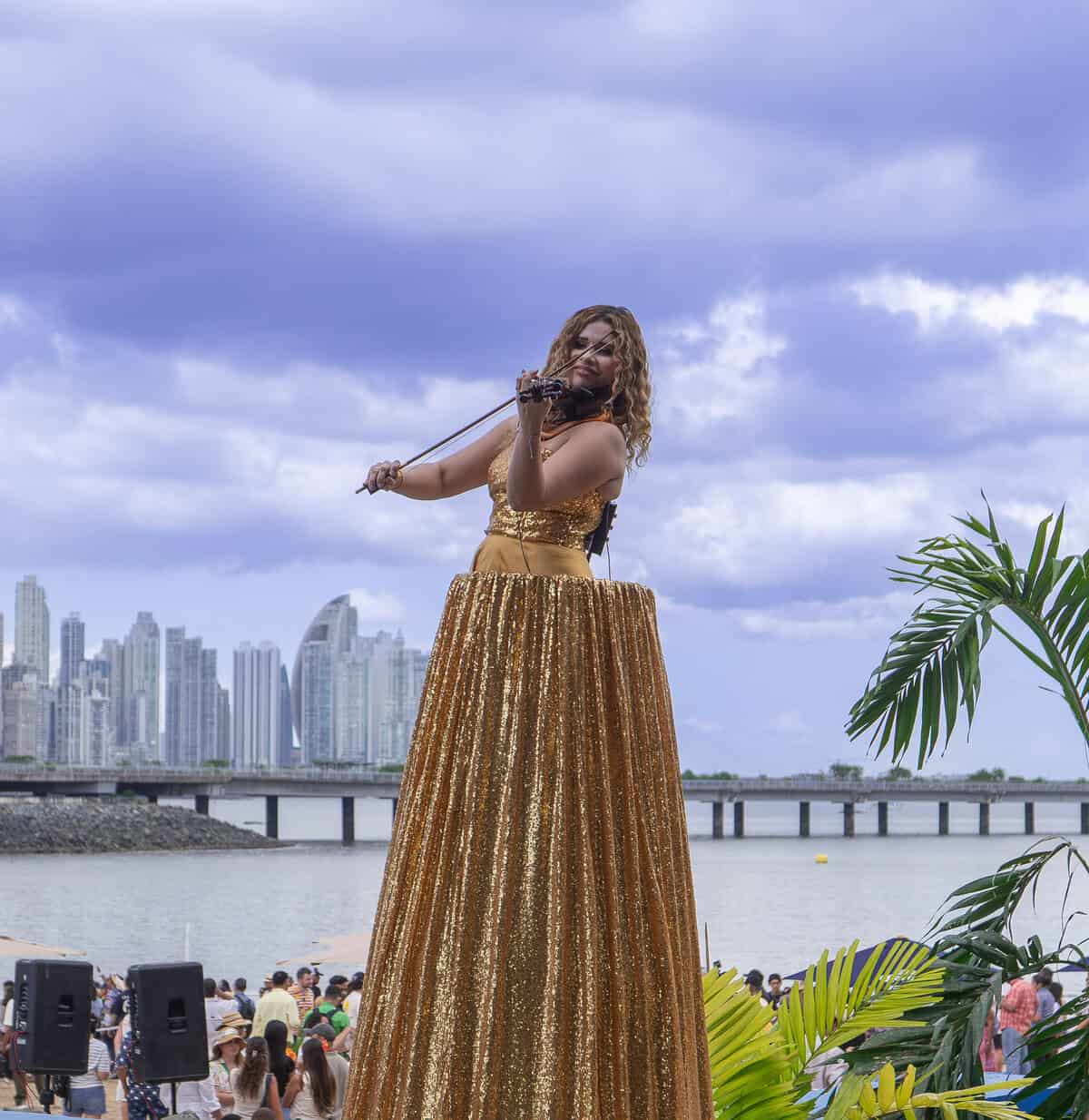 Performer welcoming visitors at the beach during Casco Peatonal in Casco Viejo, Panama City skyline in the background