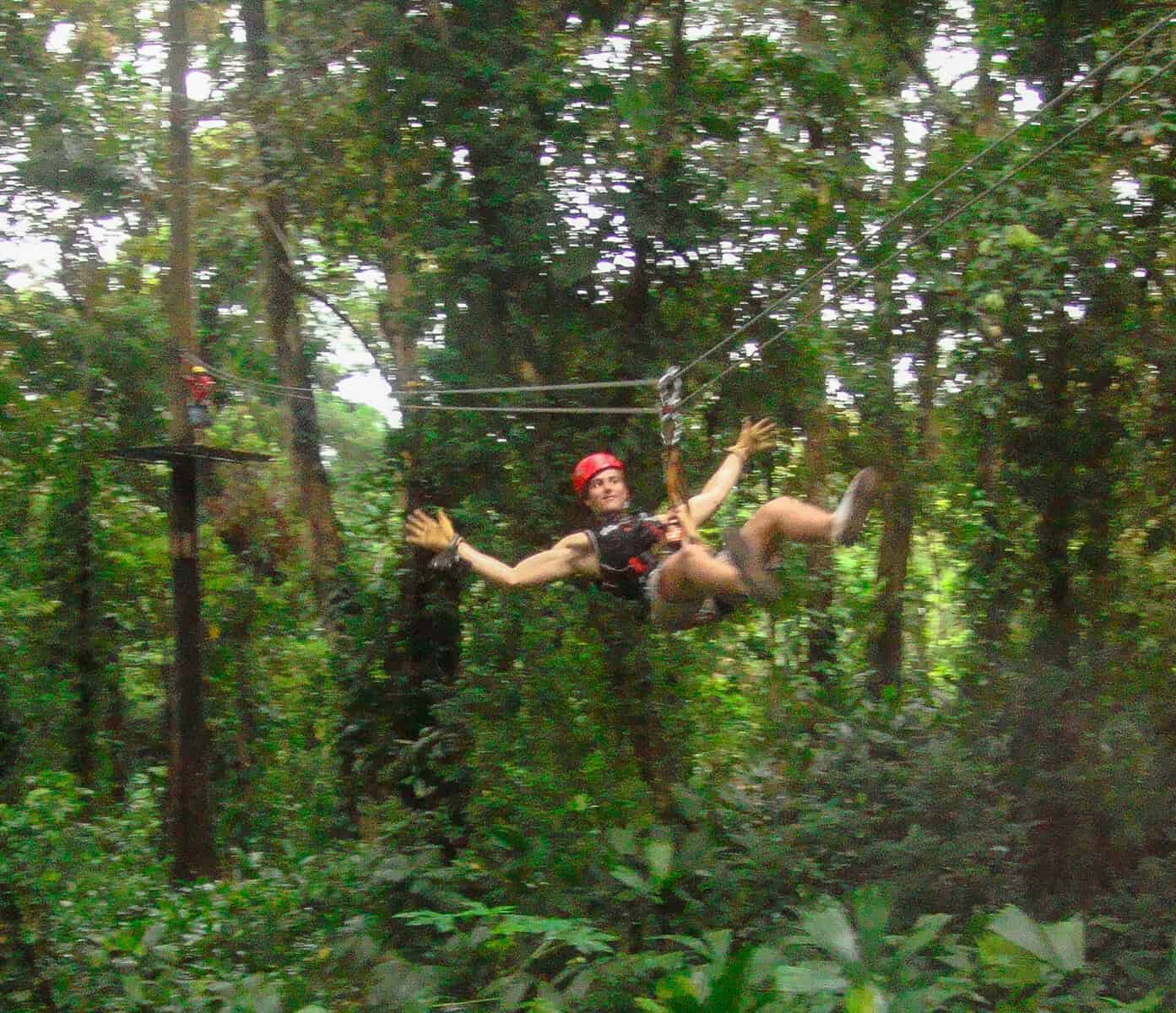 zipline at Red Frog Beach Resort Bastimentos Bocas del Toro Panama with guest gliding through tropical rainforest canopy