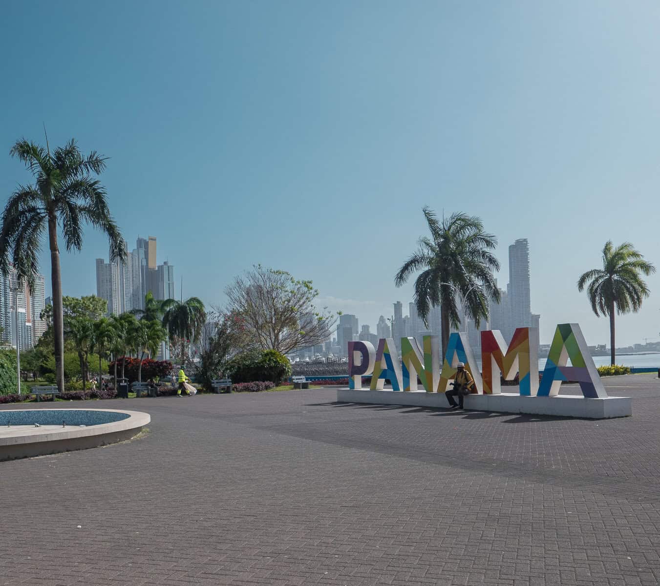 PANAMA sign on Cinta Costera 2 near Casco Viejo with palm trees and Panama City skyline along the waterfront.