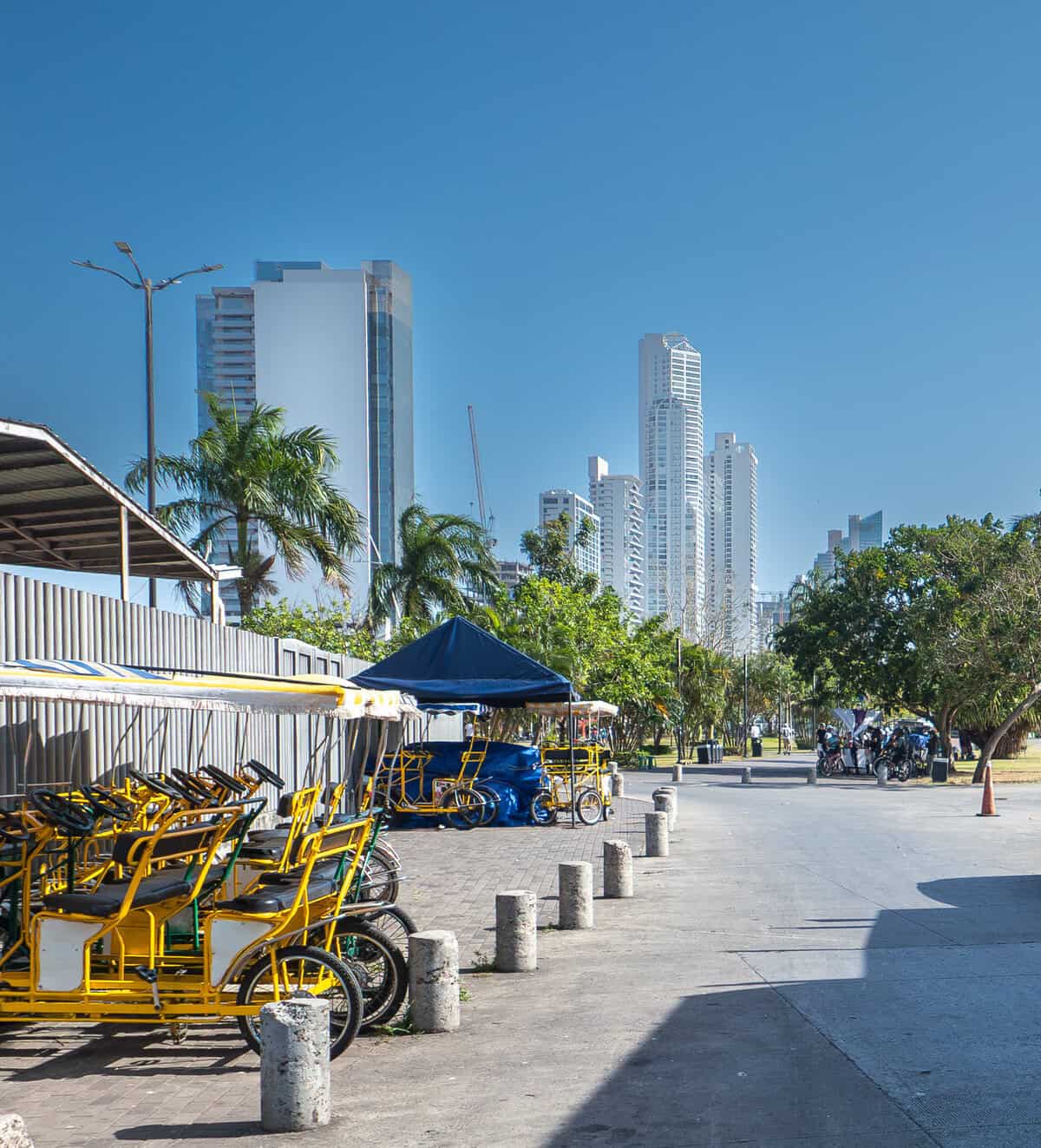 Pedal cart and bike rentals along Cinta Costera 2 near Casco Viejo Panama with modern skyline and palm-lined waterfront promenade.
