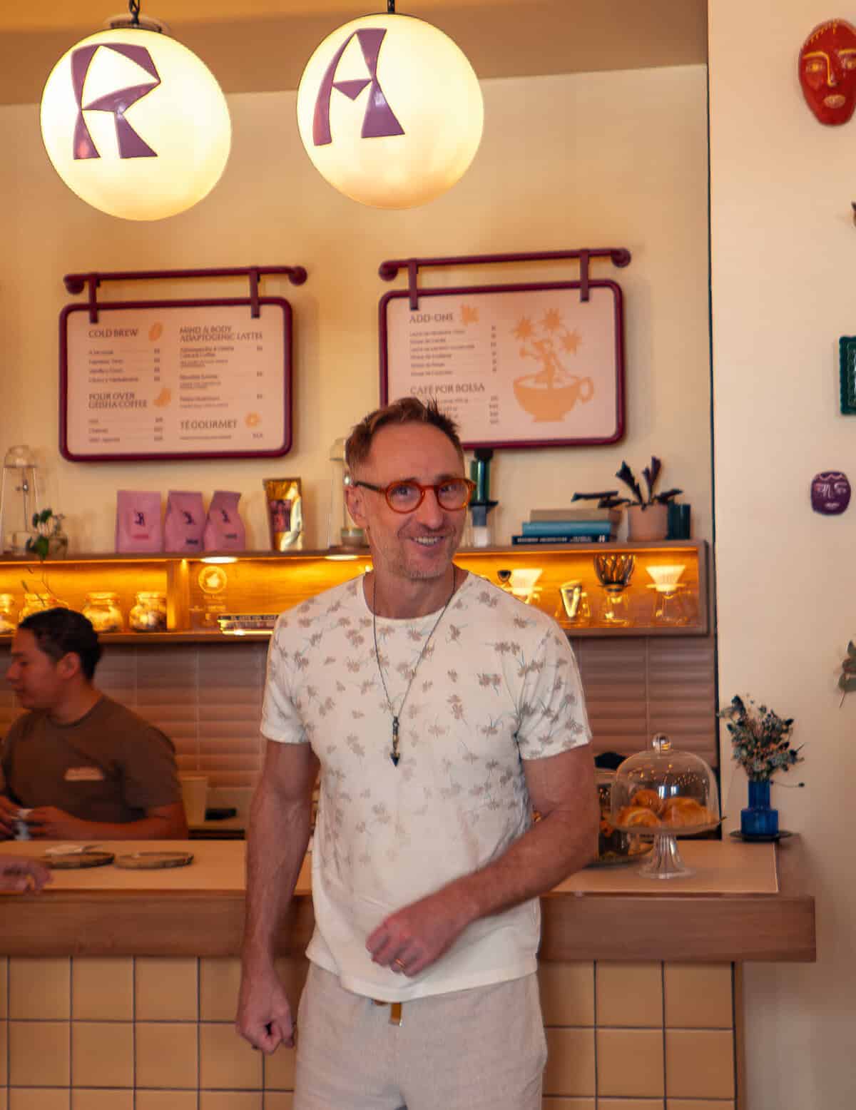 Matthew at Tantalo Hotel café in Casco Viejo Panama with staff working behind the counter in a lively setting
