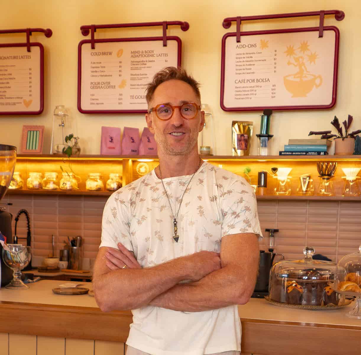 Matthew at Tantalo Hotel café in Casco Viejo Panama standing behind the counter with coffee menu in background