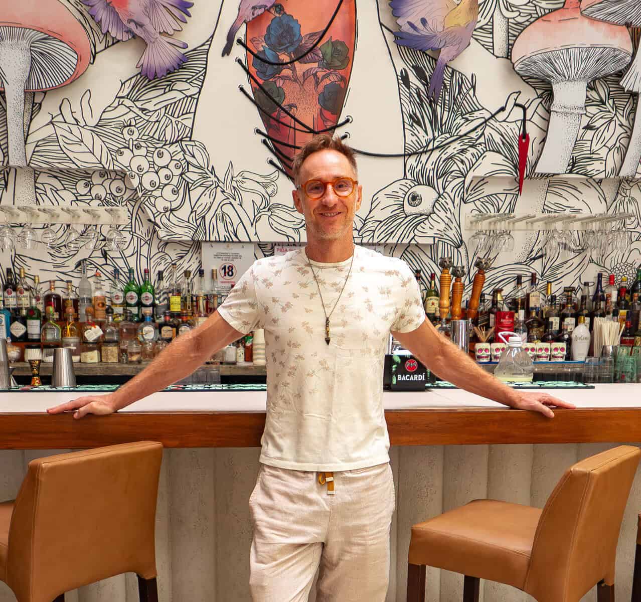 Matthew at Tantalo Hotel front desk in Casco Viejo Panama with illuminated Tantalo logo behind