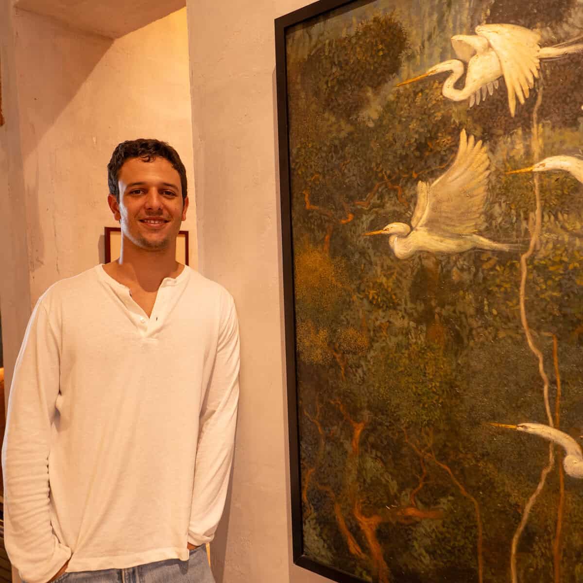 Paulo standing beside artwork inside Olympia Coffee Studio Casco Viejo Panama
