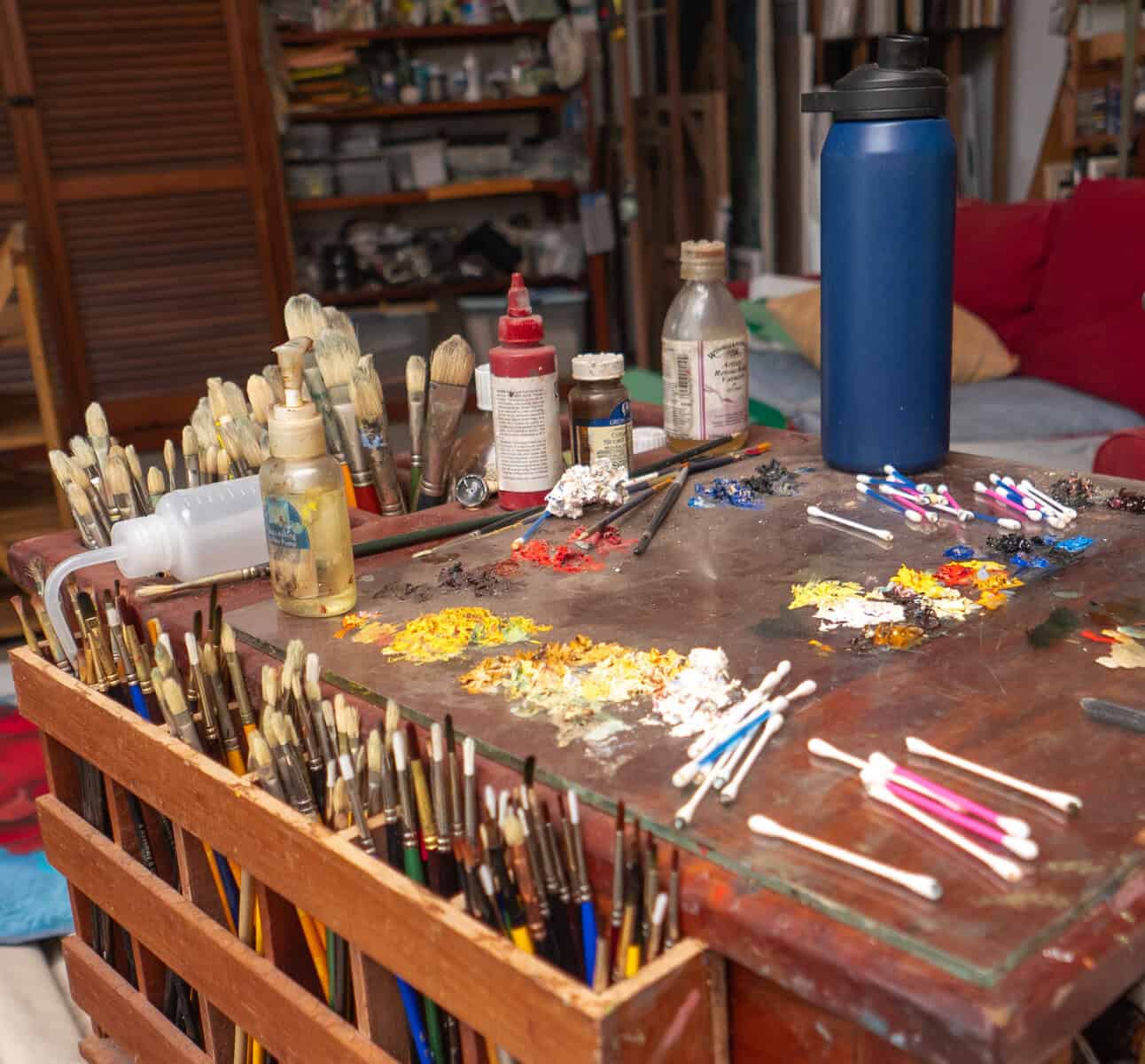 Artist worktable with brushes and paint inside Brooke Alfaro studio Panama