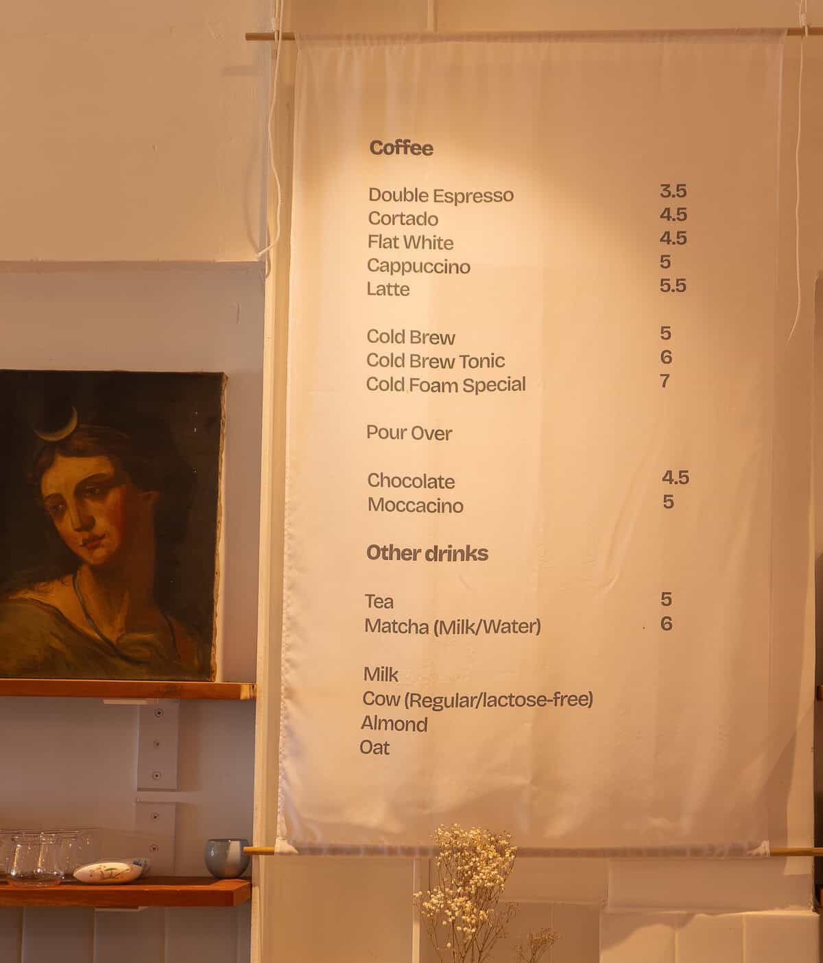 Active interior scene at Olympia Coffee Studio in Casco Viejo, Panama showing guests gathered around the coffee bar. The image captures the social energy and natural flow of the space during service.