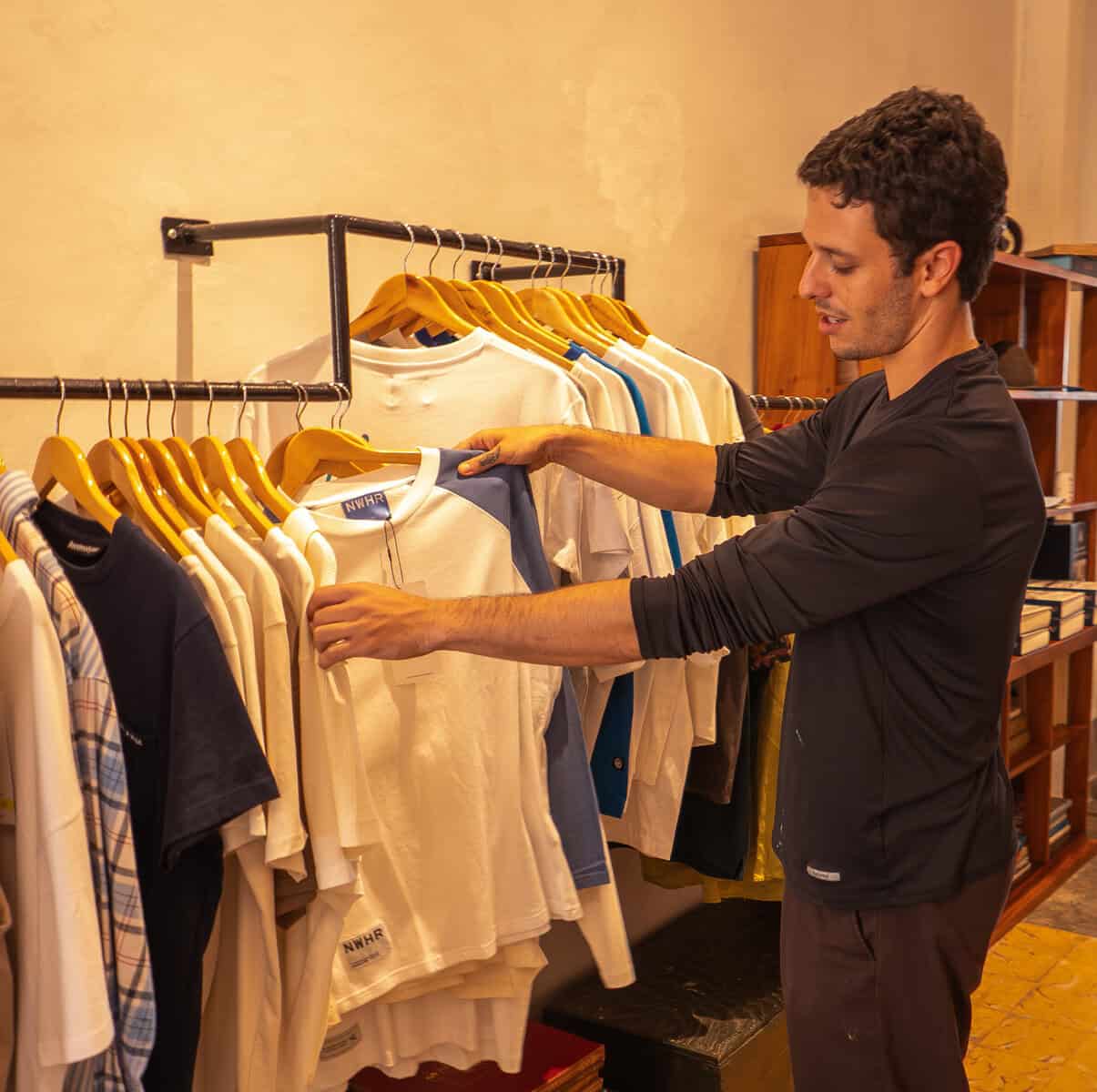 Paulo arranging clothing for sale inside Olympia Coffee Studio Casco Viejo Panama