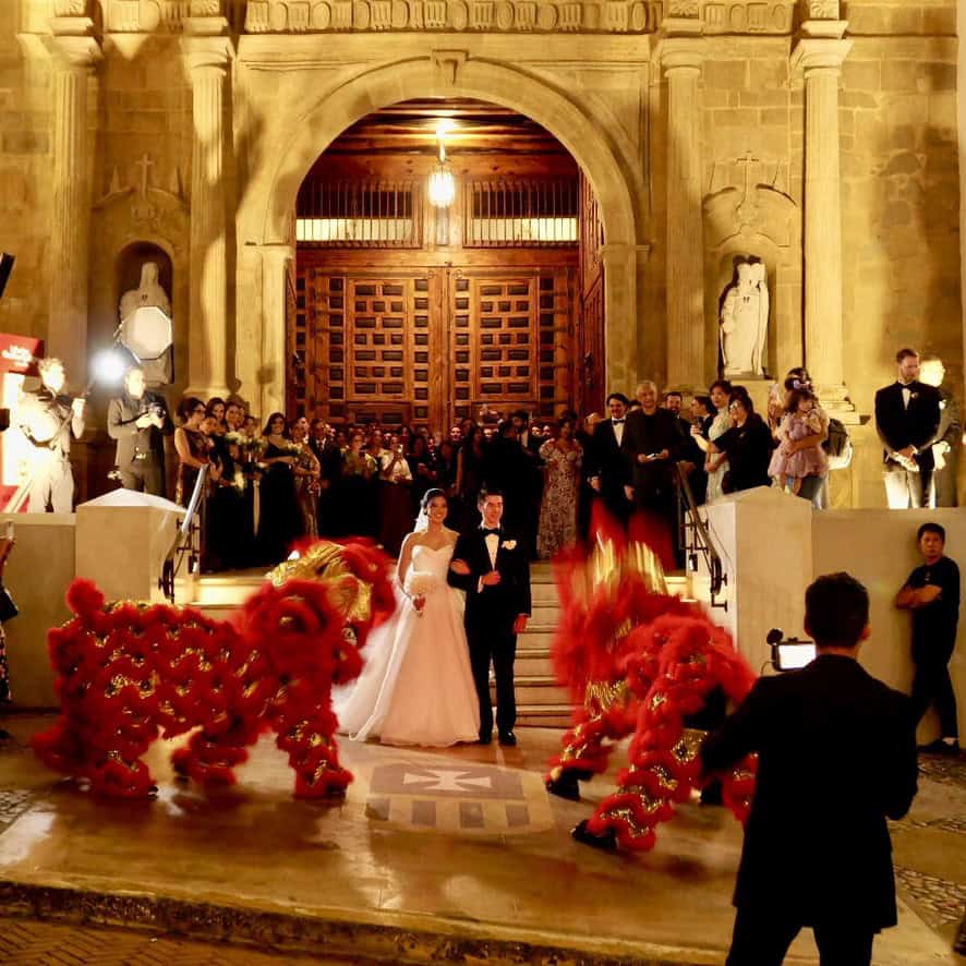 Bride and groom celebrate outside La Merced Church in Casco Viejo with a traditional Chinese lion dance.