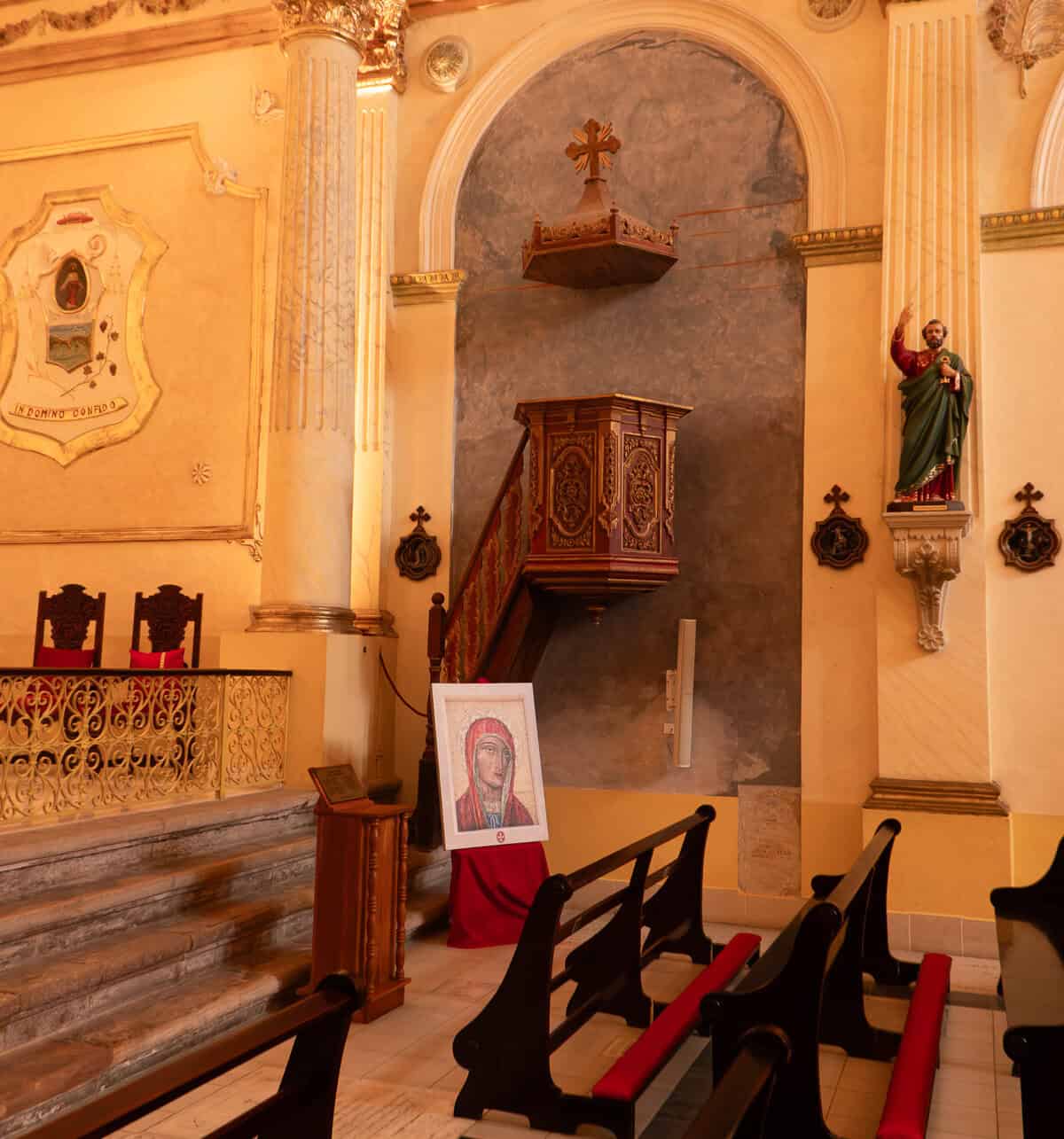 Interior view of the Oratorio San Felipe Neri in Casco Viejo, Panama City, featuring the historic pulpit, colonial architecture, pews, and a devotional statue.