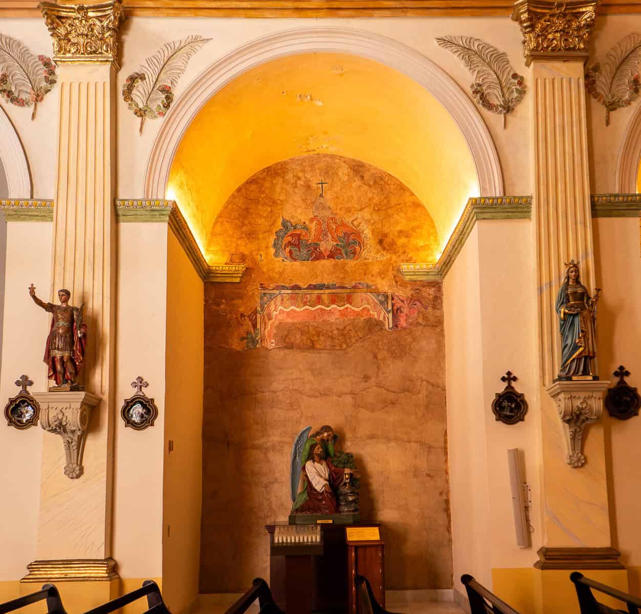 Side chapel inside the Oratorio San Felipe Neri in Casco Viejo, Panama City, featuring a devotional altar framed by elegant colonial architecture and religious statues.