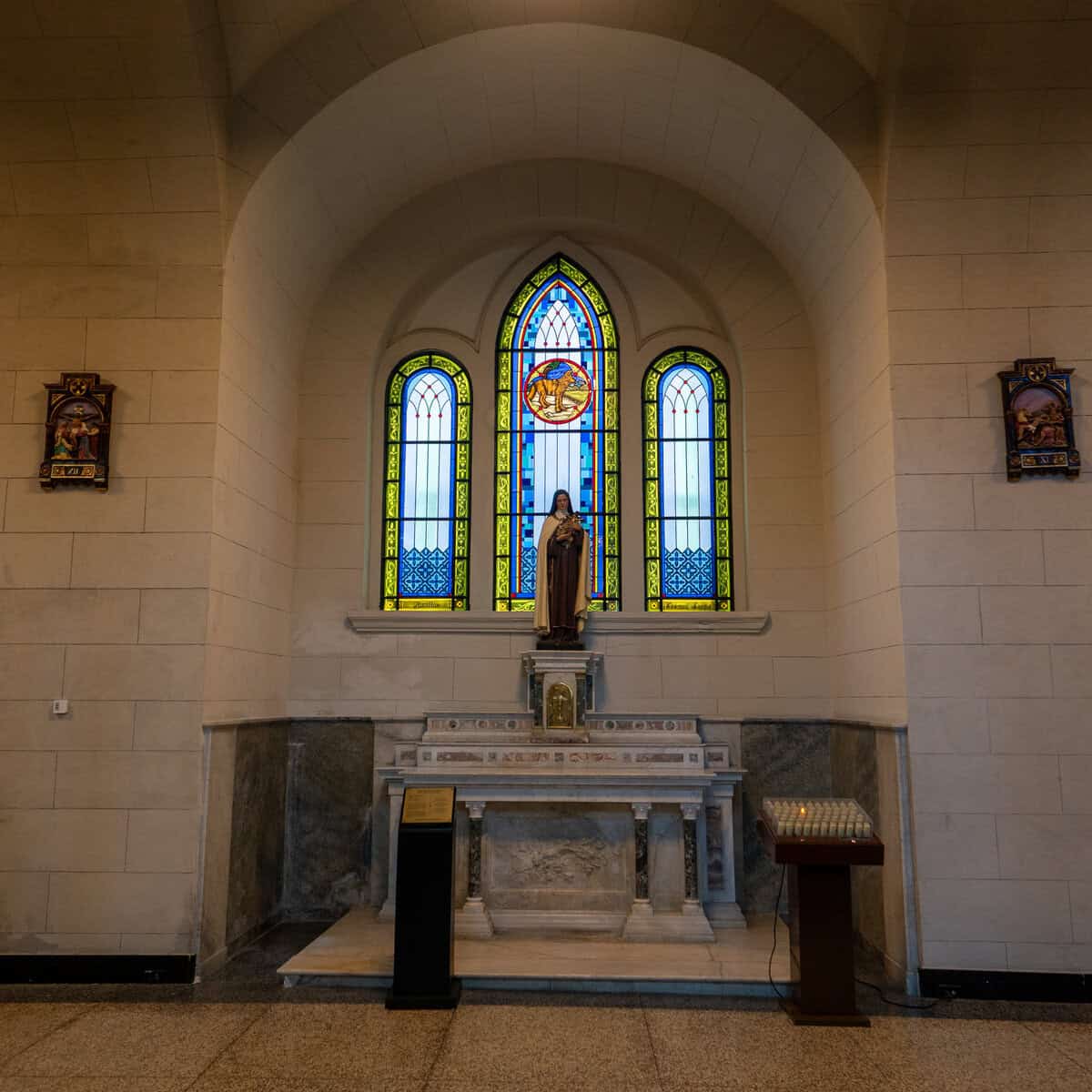 Side altar beneath stained-glass windows inside San Francisco Church (Iglesia San Francisco de Asís) in Casco Viejo, Panama City.