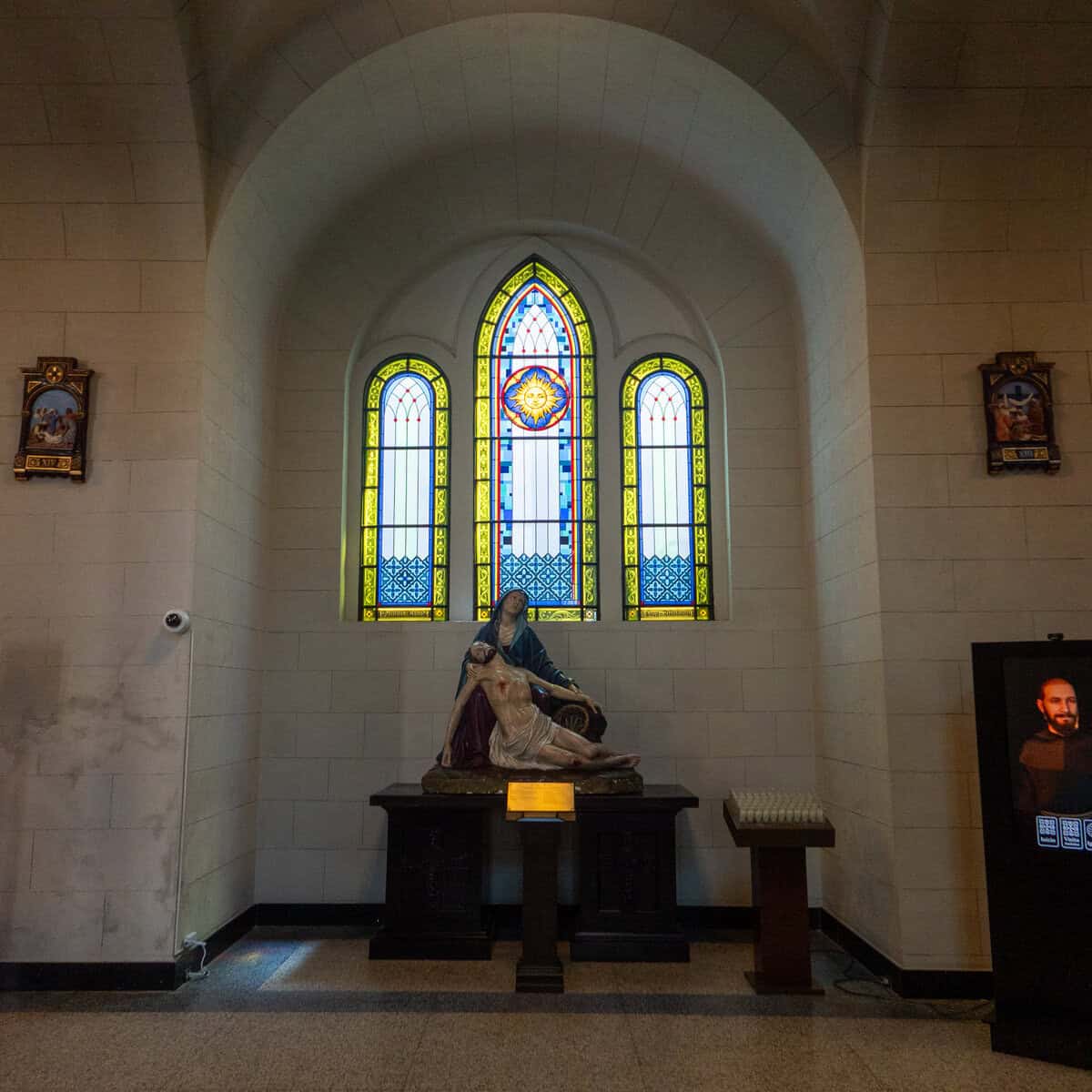 Pietà statue beneath stained-glass windows inside San Francisco Church (Iglesia San Francisco de Asís) in Casco Viejo, Panama City.