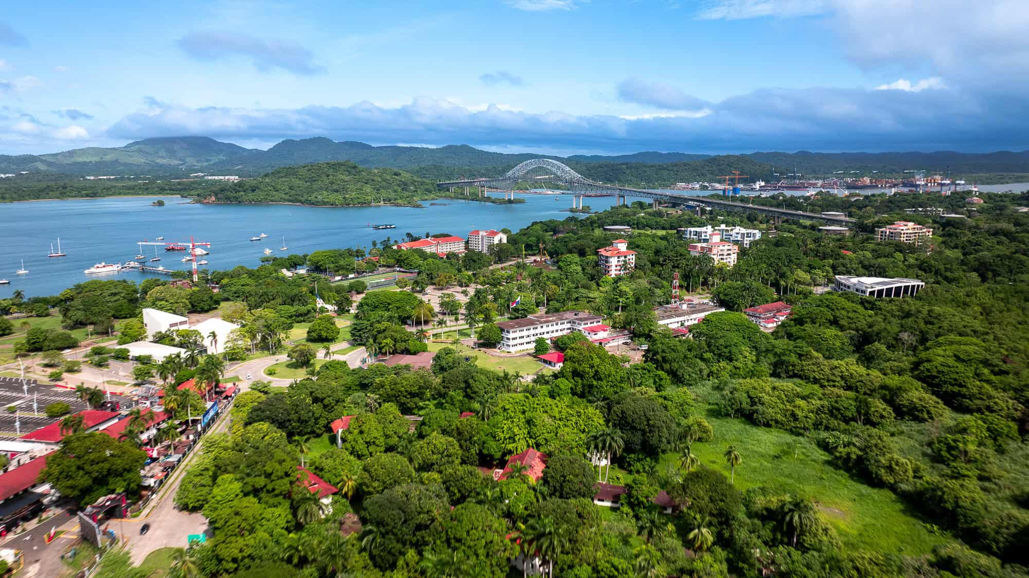 Aerial view of the Bridge of the Americas, the Pacific entrance to the Panama Canal, and the tropical landscape surrounding Panama City.