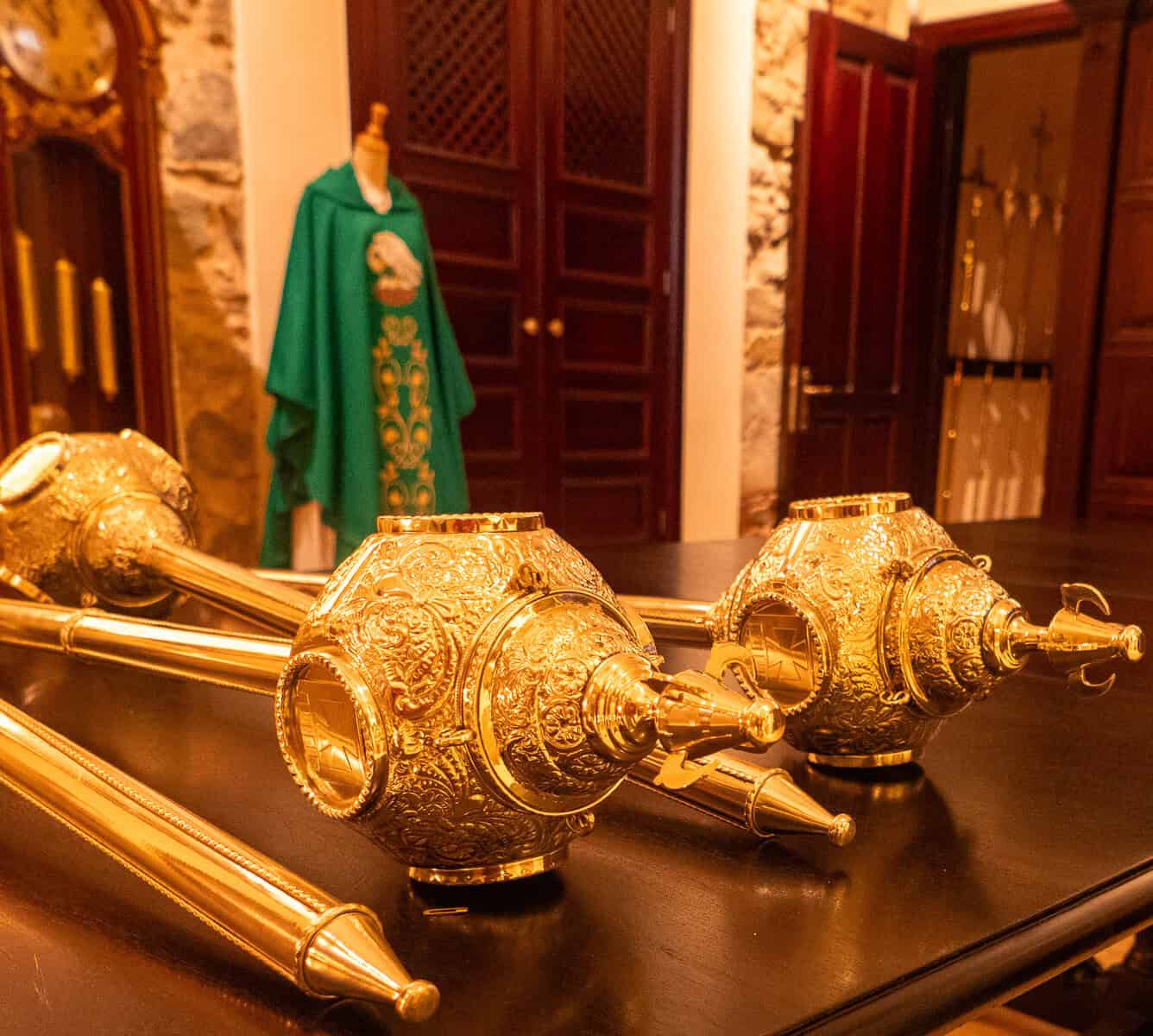 Historic silver-gilt processional staff finials and liturgical vestments displayed in the Museum of La Merced, Casco Viejo, Panama City.