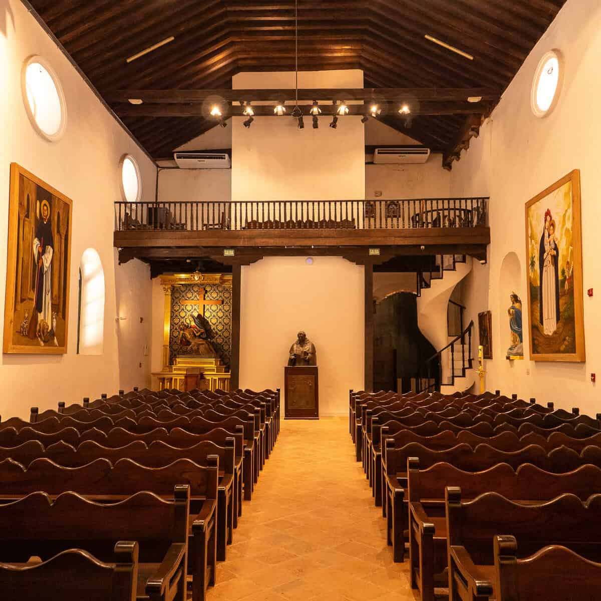 Interior of Iglesia Santo Domingo de Guzmán in Casco Viejo showing the wooden pews, choir loft and timber ceiling.