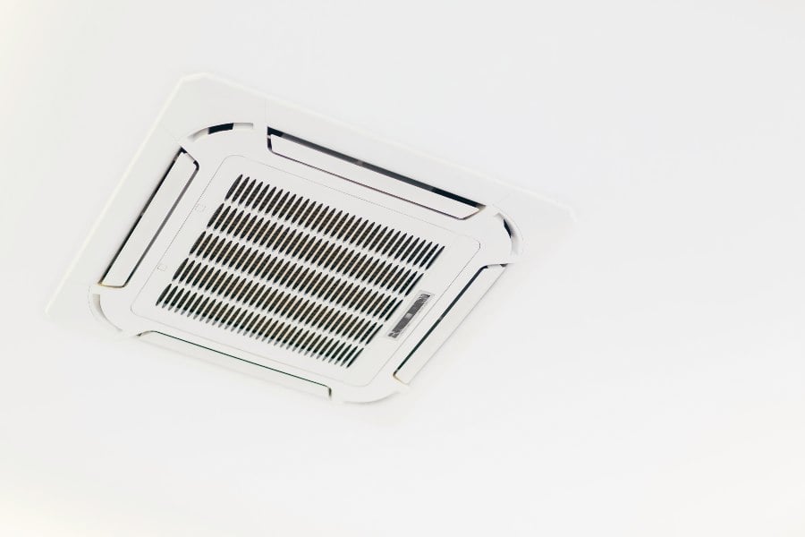 Ceiling-mounted ducted air conditioning vent for modern reverse cycle cooling and heating.