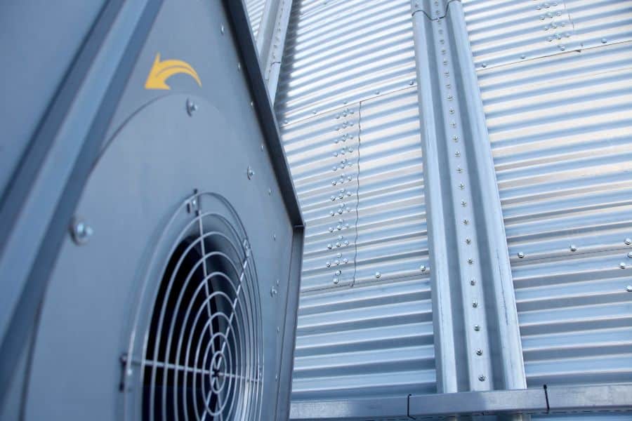 Close-up of an industrial evaporative cooling unit with a large metal fan and vented panel.
