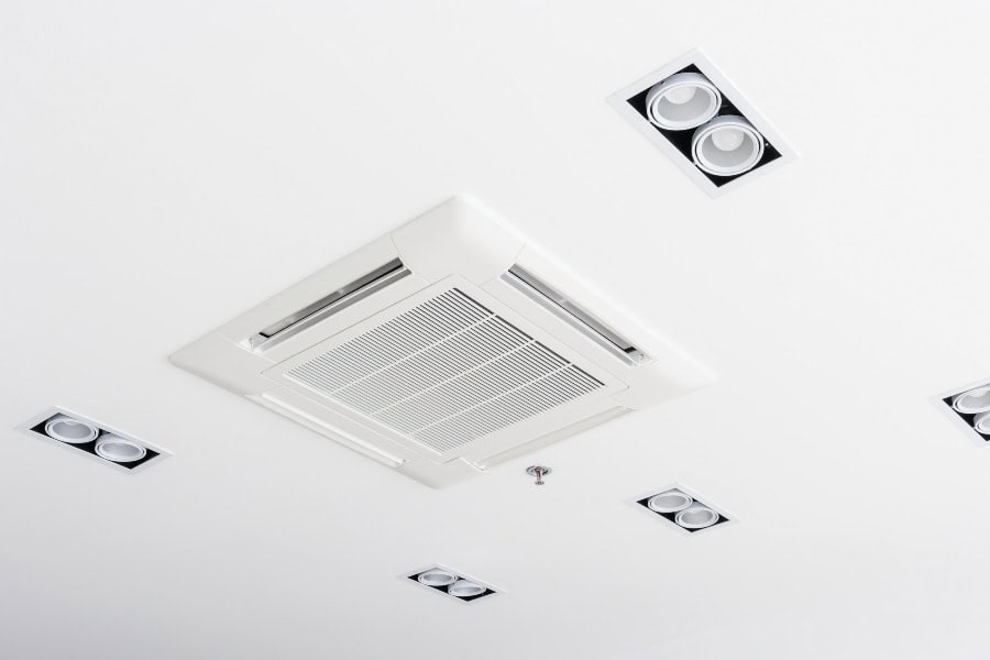 Ceiling-mounted ducted air conditioning cassette in a modern indoor space.