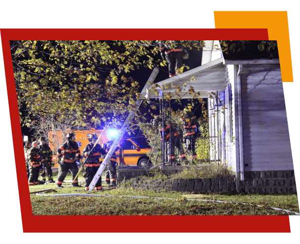 Firefighters working at night outside burning house