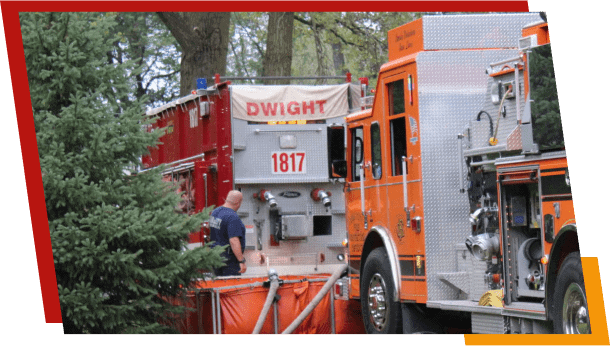 Firefighter preparing hose near Dwight fire truck