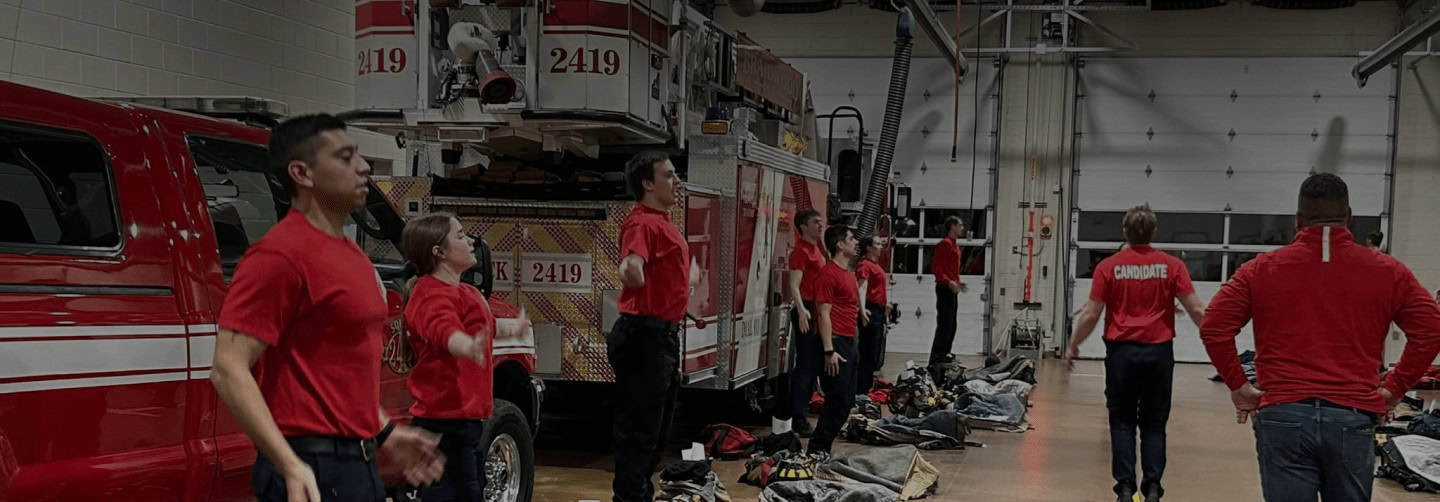 Firefighters training in garage with firetruck and gear