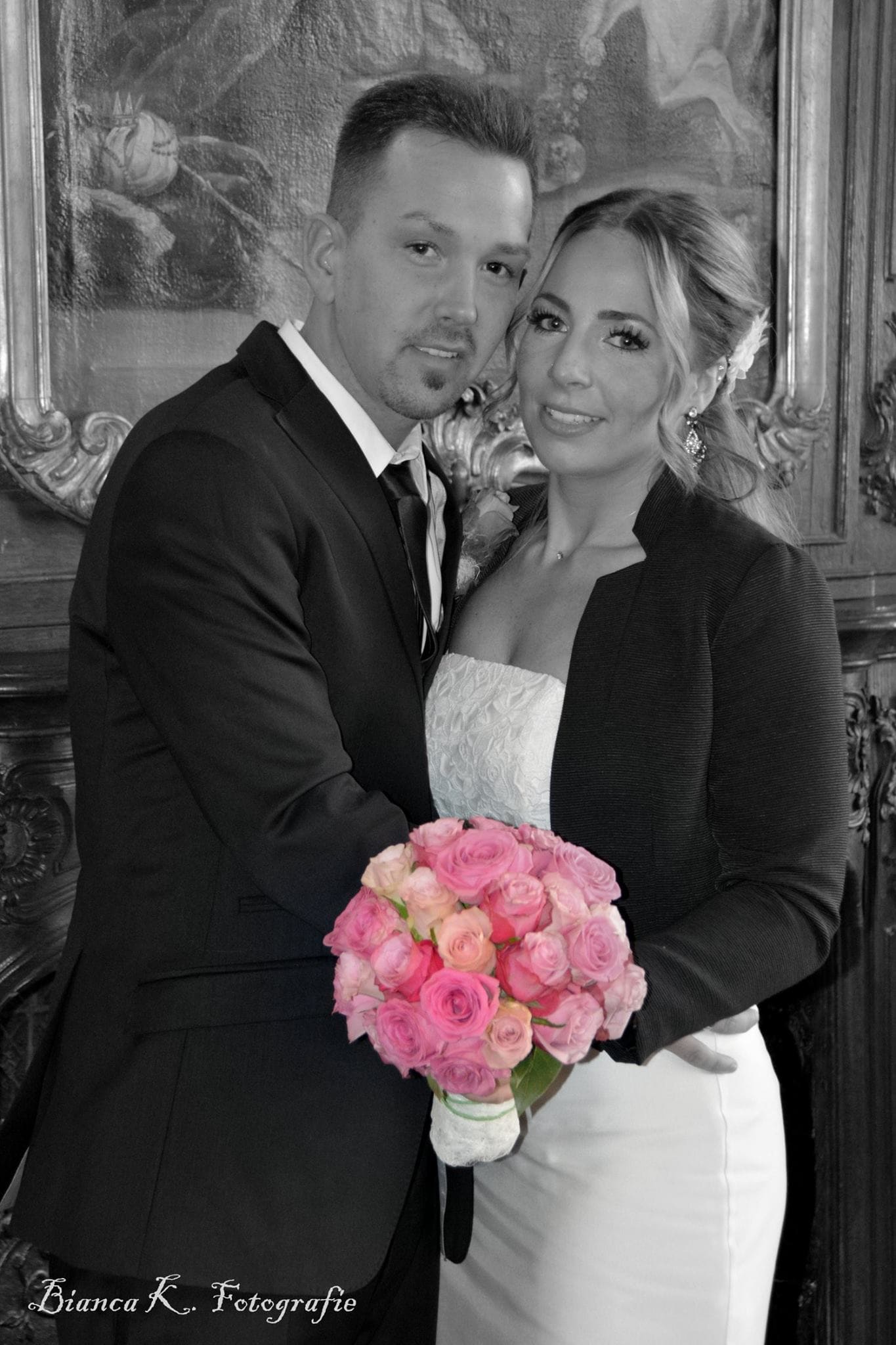 Brautpaar in schwarz weiß mit buntem Blumenstrauss