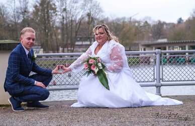 Hochzeitsfotograf Aachen, Braut und Bräutigam am Flussufer, kreative Liebesgeschichte.
