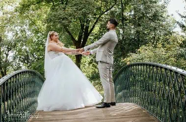 Hochzeitsfoto eines Paares auf einer Brücke im Park, romantisches Traumbild bei natürlichem Licht.