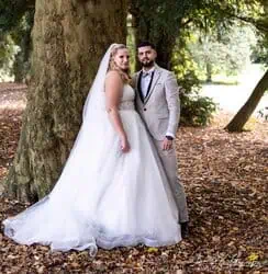 Hochzeitsfotografie im Park mit Braut und Bräutigam vor Baum im Herbst.