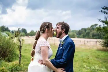 Hochzeitspaar teilt Apfel in der Natur, kreative Hochzeitsfotografie im Grünen.