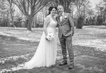 Romantisches Hochzeitsfoto eines Brautpaares im Park bei winterlichem Wetter.