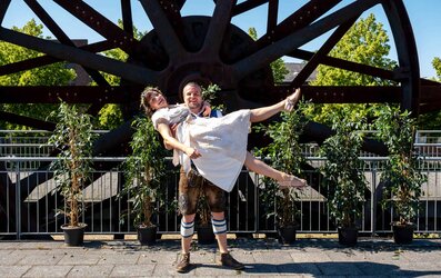 Frischer Hochzeitsmoment vor einem nostalgischen Industrie-Rad in Aachen.