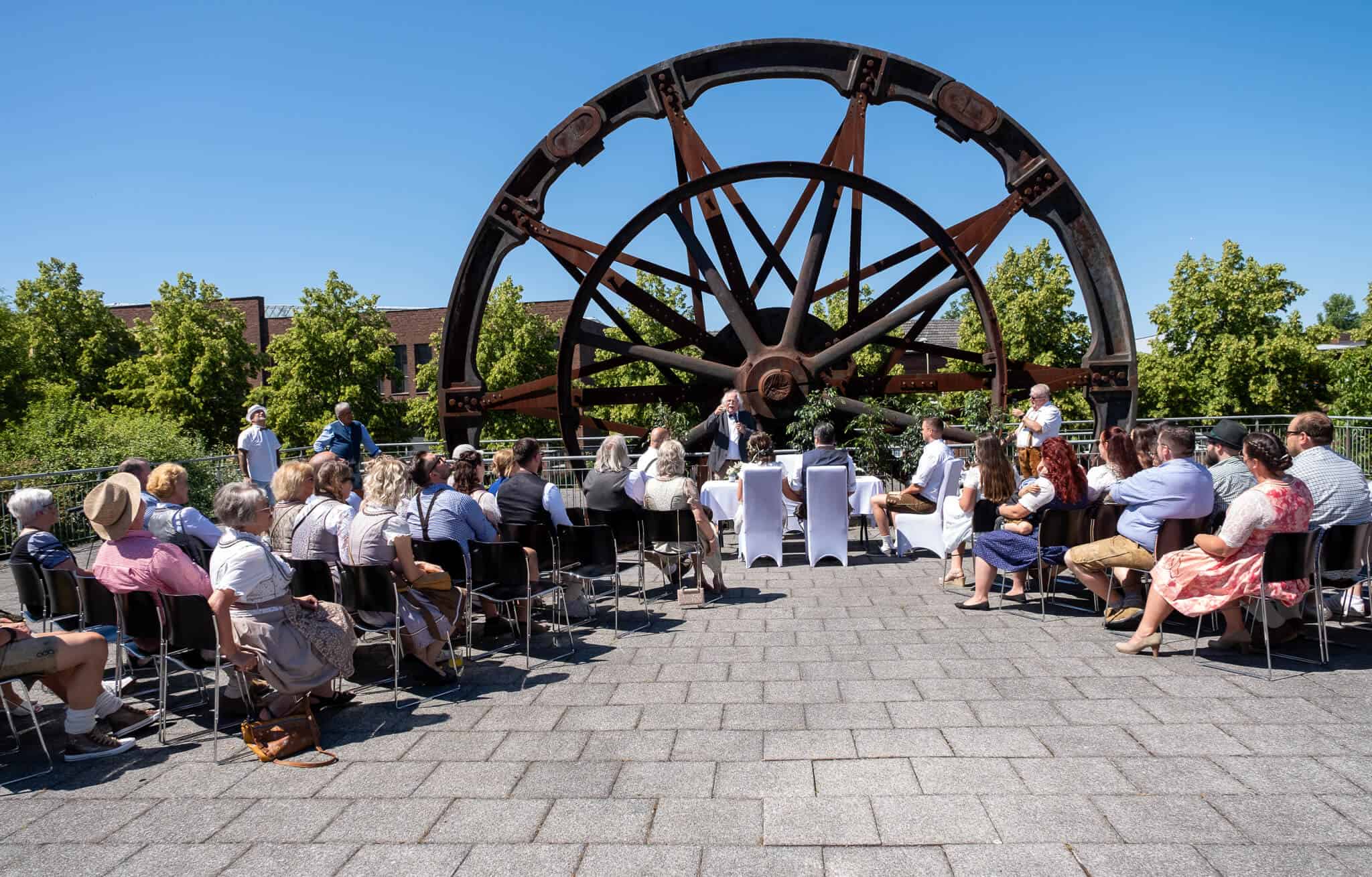 Historischer Waggon als Kulisse für eine Hochzeitszeremonie im Freien an einem sonnigen Tag.