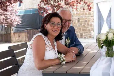 Freude bei einer Hochzeit im Garten, Braut und Bräutigam beim Sitzen am Tisch, romantisch dekoriert.