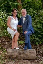 Elegantes Hochzeitsportrait im Wald mit Braut und Bräutigam in moderner Kleidung.