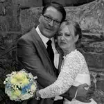 verliebtes Brautpaar in sepia mit gelbem Blumenstrauss