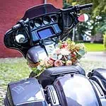 Motorrad mit Blumenstrauß für Hochzeit, romantische Hochzeitsauto-Dekoration, elegante Motorradsaison im Sommer, Hochzeitsfahrzeug Dekor.