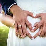 Verliebtes Brautpaar mit Händen in Herzform, Nahaufnahme, Hochzeitsfotografie in Aachen.