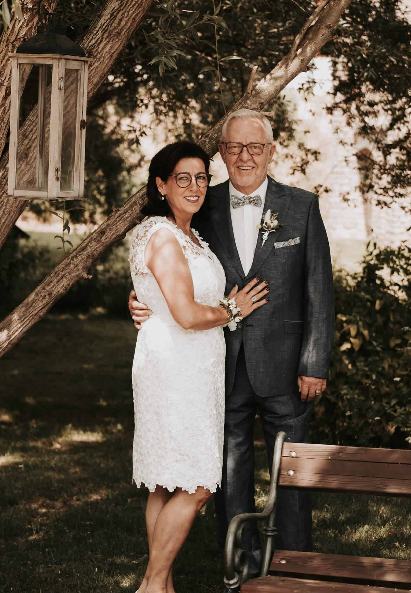 Hochzeitsfotograf Aachen - Brautpaar im Garten mit Baum und Laterne.