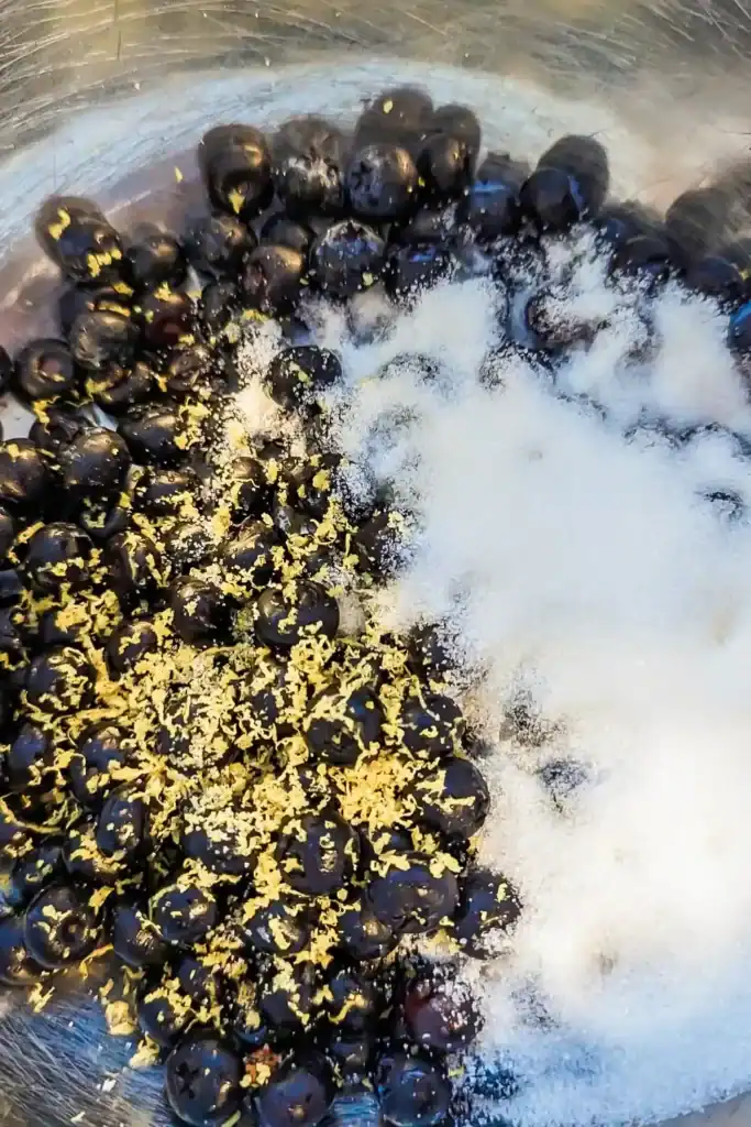 adding white sugar to lemon and blueberry