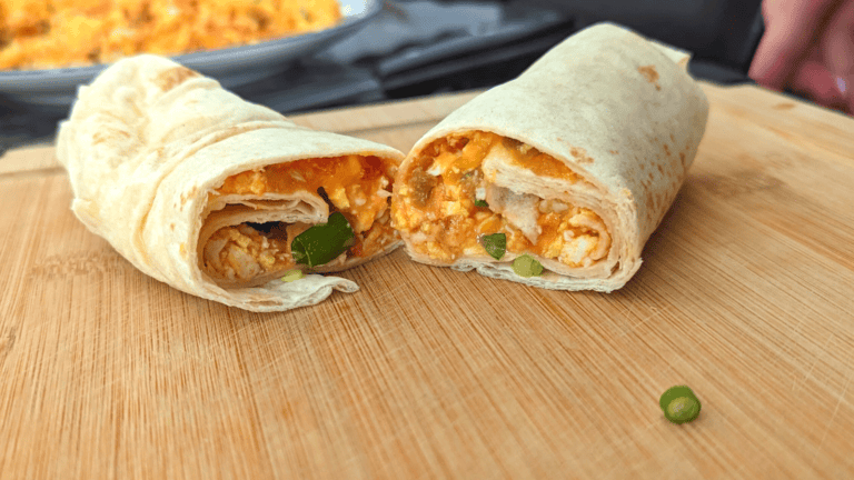 salsa egg breakfast burrito on wood cutting board
