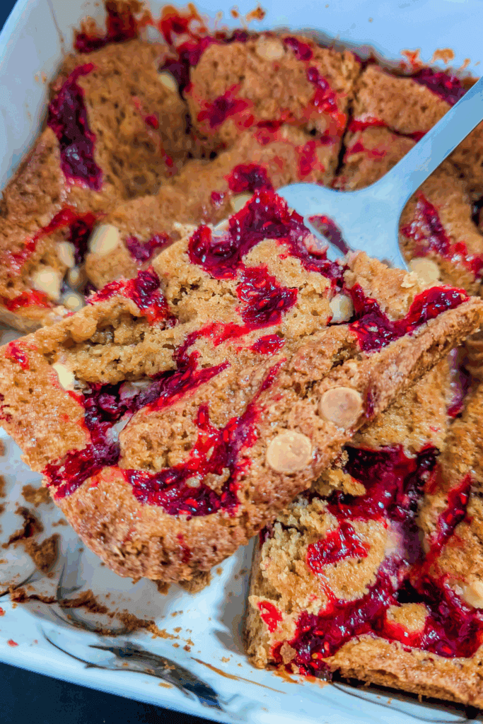 lifting a piece of blondie from the pan