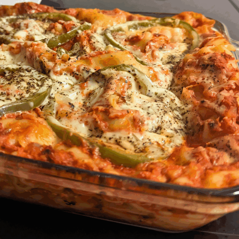 A casserole dish with cheese and peppers on top.