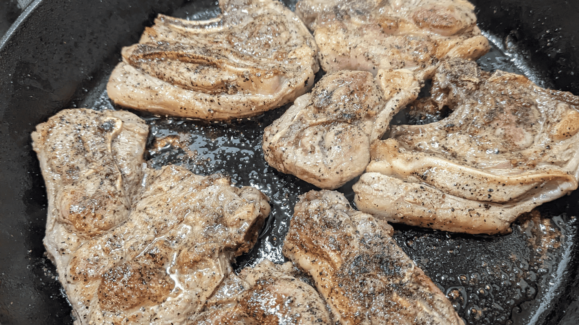 lamb chops browning in cast iron pan