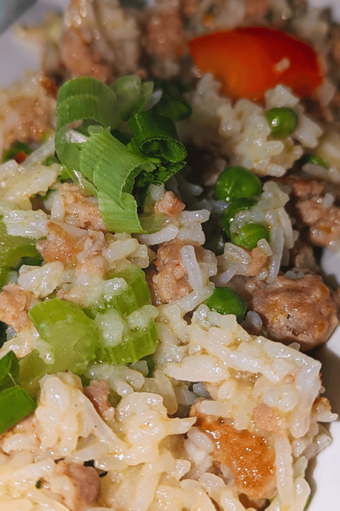 add green onion to spicy sausage fried rice dinner