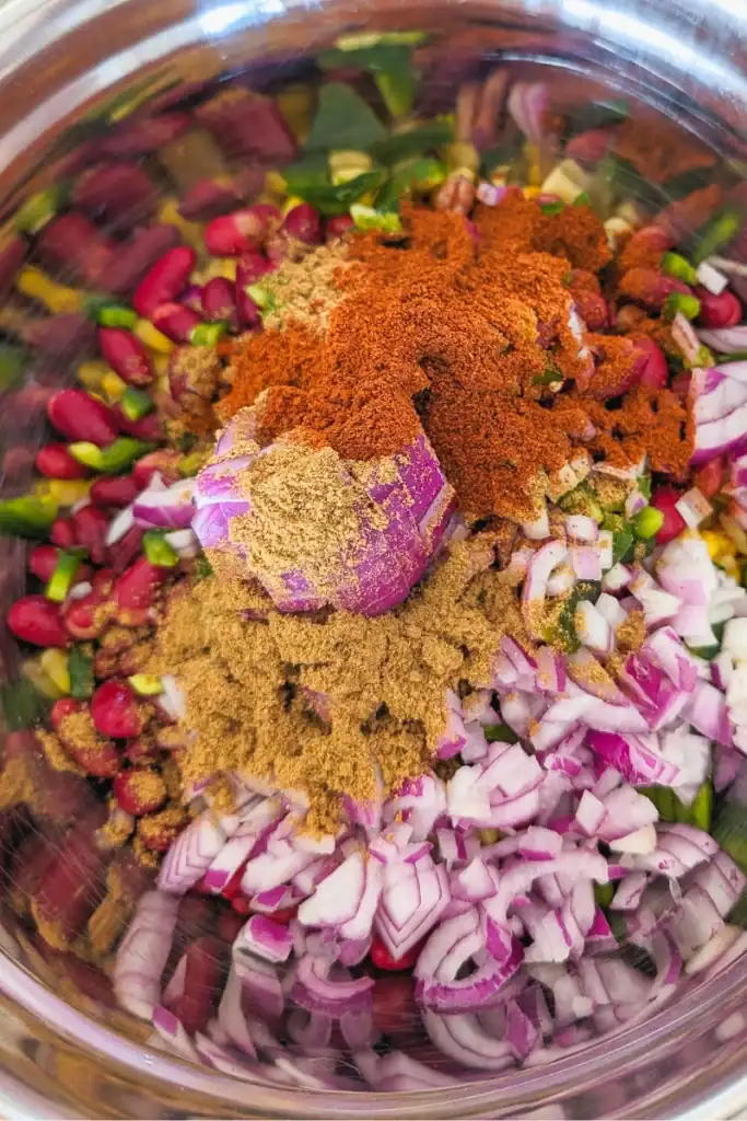 adding spices to corn salad